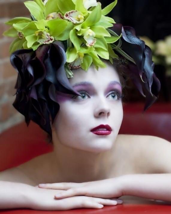 Close up of a model with makeup and flowers on her head